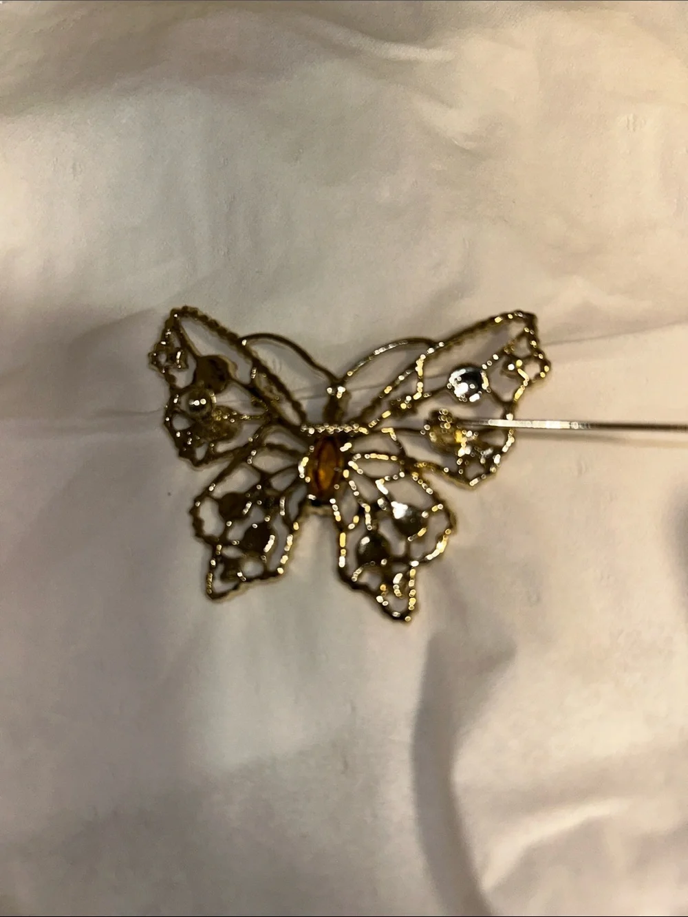 Dodds filigree butterfly brooch featuring a large amethyst-colored center stone
